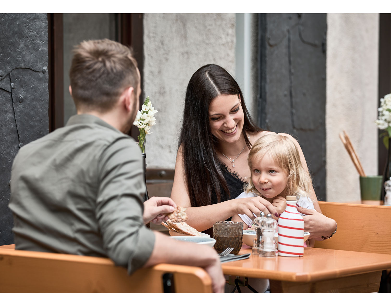 Due adulti e un bambino sono seduti sul set da birreria corto Shorty.