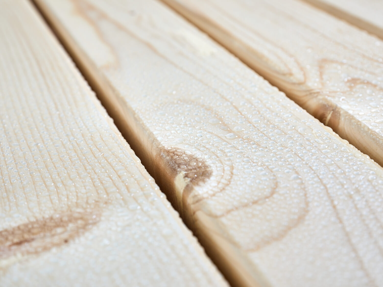 Set di design SitDown con gocce d'acqua sulla superficie del legno. Lo smalto UV protegge il piano del tavolo da deformazioni e scolorimenti. Il set è quindi resistente agli agenti atmosferici e ignifugo.
