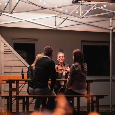 Designgarnitur Rustica im Garten Eine gesellige Runde von vier Personen sitzt auf einer Rustica-Sitzgruppe im Garten.
