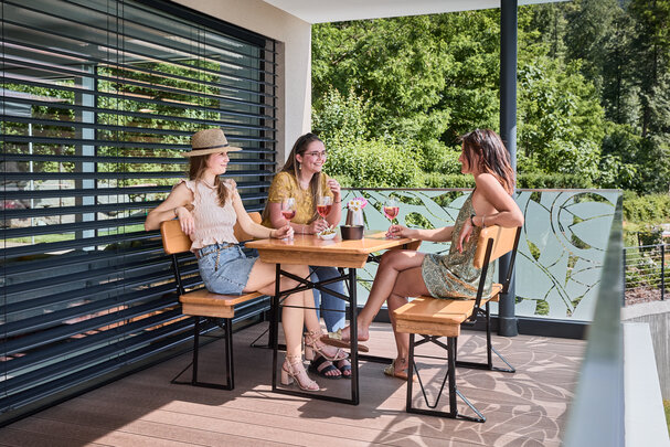 Friends sit together on the small beer garden table set Shorty with backrest.