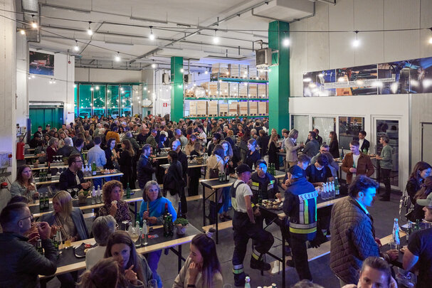 Stehtische Stand Up in einer Halle bei einem Event Bei einem Indoor-Event stehen zahlreiche Personen an den Stehtischen Stand Up.