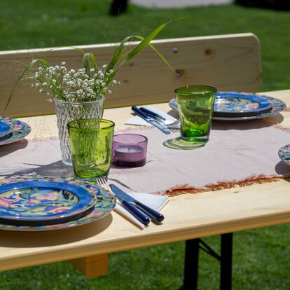 A beautifully set beer garden table A beautifully set beer garden table with plates, glasses, and flowers.