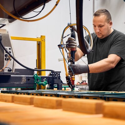 Montage der Untergestelle und Verschlussmechanismen Im Bild werden in der Werkstatt die Untergestelle und Verschlussmechanismen Bierbänke montiert.
