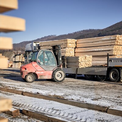 Das Bild zeigt einen Stapler, der Holzlatten für die Bierzeltgarnituren auf einen LKW lädt.