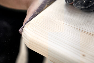 Before painting, the corners of a beer bench are carefully hand-filed with skill and precision.