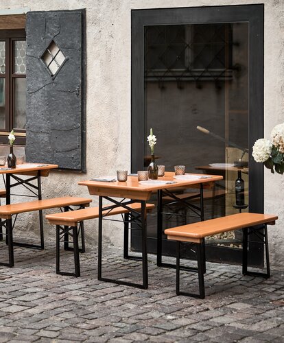 Small beer garden table set Shorty in the alley Several small beer garden table sets were placed in an outdoor area.