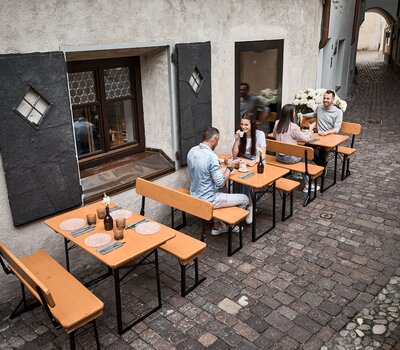 Bierzeltgarnitur Shorty Gastronomy Gasse Drei Bierzeltgarnituren stehen vor einem Restaurant in einer Gasse.