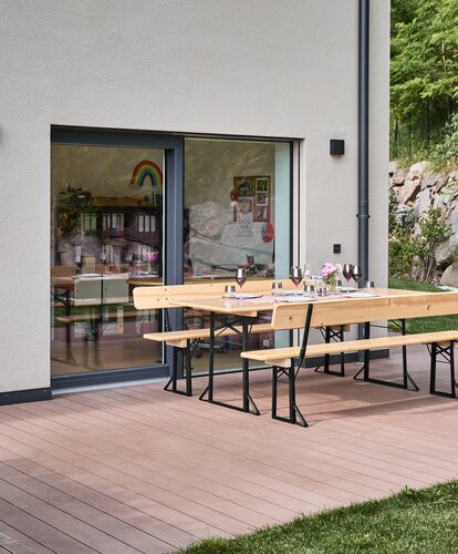 Wide beer garden table set with backrest in nature  The wide beer garden table set stands covered on the terrace.