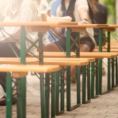 Mulitple beer garden table sets are set up on a terrace.