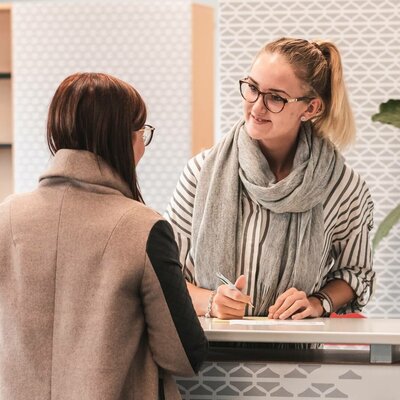 A staff member assisting a client The photo shows a staff member providing information and advice to a customer.