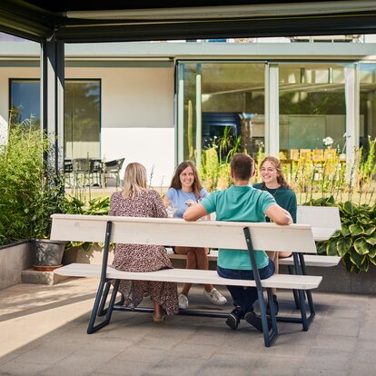Man sieht eine Riva-Designgarnitur, die in einem Garten steht. 