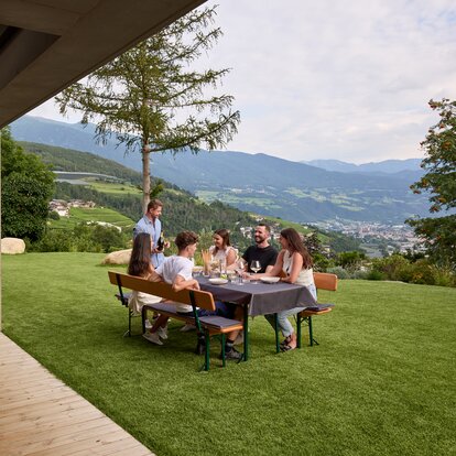 Several people sit at the beer garden table and spend a convivial evening.