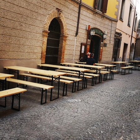 Classic beer garden table sets in nature in front of the Maeves Pub.