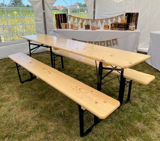 Klassische Bierzeltgarnitur in Natur für eine Party Die klassische Bierzeltgarnitur in Natur wird für eine Party in einem Festzelt verwendet.