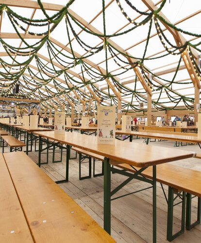 Beer tent sets Oktoberfest The image shows the interior of an Oktoberfest tent with rows of RUKU1952 Classic beer tent sets.