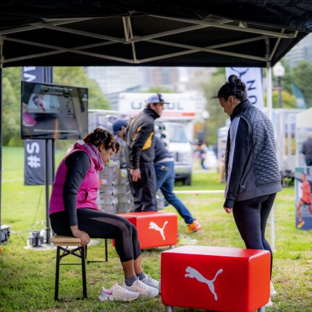 At the 10k Puma Marathon for Women in Boston, women sat on the small beer bench to try on shoes.
